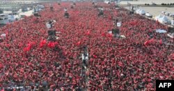 Orang-orang mengibarkan bendera Turki dan Palestina saat Presiden Turki berbicara dalam rapat umum yang diselenggarakan oleh partai AKP dalam solidaritas dengan rakyat Palestina di Gaza, di Istanbul pada 28 Oktober 2023. (Foto: AFP)