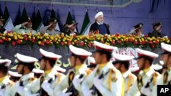 Presiden Iran Hassan Rouhani, atas tengah, menyaksikan pasukan militer berparade pada peringatan 38 tahun invasi Irak terhadap Iran, di depan makam pemimpin revolusioner, Ayatollah Khomeini, di luar Teheran, Iran, 22 September 2018.