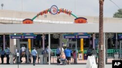 Para pengunjung memasuki pintu masuk "Magic Kingdom" salah satu taman hiburan Walt Disney World, saat pembukaan kembali di Lake Buena Vista, Florida, 11 Juli 2020. 