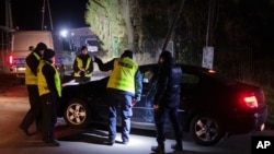 Police officers gather outside a grain depot in Przewodow, eastern Poland, where a blast that killed two people was reportedly caused by a stray Russian missile on Nov. 15, 2022. Russia has denied the allegation.