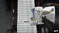 资料照片：肯尼亚首都内罗毕一名技术人员正在检查当地出版的《中国日报》印刷（2013年1月3日）