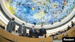 Delegates stand for a minute of silence for Britain's Queen Elizabeth, following her death, during the Human Rights Council in Geneva, Sept. 12, 2022. Picture taken with a fish-eye lens. 