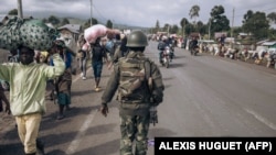 Un soldat congolais marche à Kanyaruchinya, au nord de la ville de Goma, dans l'est de la République démocratique du Congo, alors que des personnes déplacées par la guerre fuient vers le sud, le 15 novembre 2022.