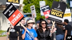 FILE - Meredith Stiehm, left, president of Writers Guild of America West, and Fran Drescher, president of SAG-AFTRA, take part in a rally by striking writers outside Paramount Pictures studio in Los Angeles on May 8, 2023.