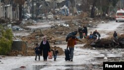 Palestinians fleeing north Gaza move southward as ambulances head towards north Gaza during a temporary truce between Israel and Hamas, near Gaza City, Nov. 27, 2023.