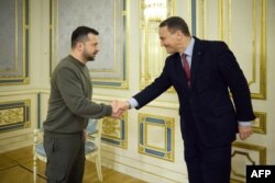 Ukrainian President Volodymyr Zelenskyy greets Polish Foreign Minister Radoslaw Sikorski in Kyiv, Dec. 22, 2023. Sikorski urged Kyiv's allies to mobilize their economies to back Ukraine's military against Russia. (Ukrainian Presidential Press Service/AFP)