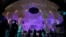 People walk near a lit up Al Wasl Dome at Expo City at the COP28 U.N. Climate Summit, Dubai, United Arab Emirates, Dec. 1, 2023.