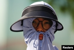 北京街头一名身穿防晒服的行人。（2023年6月30日）