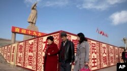 Sejumlah warga berjalan kaki melintasi patung Mao Zedong di Kashgar di bagian barat Wilayah Xinjiang, China, 4 November 2024. (Foto: Ng Han Guan/AP Photo)
