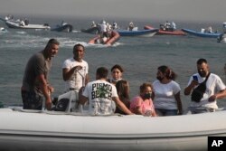 Boats arrive to help evacuate residents and tourists from the town of Nea Anchialos, near Volos city, central Greece, July 27, 2023.