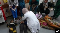 Anak-anak dan warga Palestina yang terluka dalam serangan udara dan darat Israel di Jalur Gaza dibawa ke rumah sakit di Deir al Balah, Jalur Gaza (foto: dok). 