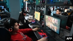 Beberapa anak-anak tampak asyik bermain game di sebuah warung internet di Beijing, pada 26 Januari 2024. (Foto: AFP/Greg Baker)