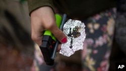 FILE - A person holds drug paraphernalia in downtown Portland, Ore., on April 4, 2023. 