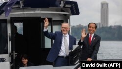 Perdana Menteri Australia Anthony Albanese (kiri) dan Presiden Joko Widodo menaiki kapal usai pertemuan tahunan di Kebun Binatang Taronga di Sydney, Selasa, 4 Juli 2023. (Foto: David Swift/Pool/AFP)