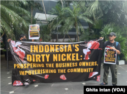 Aksi yang dilakukan oleh koalisi masyarakat sipil digelar di depan pintu masuk acara konferensi mineral kritis Indonesia 2024 psfs 11-13 Juni 2024 di Hotel Mulia, Senayan, Jakarta. (Foto: VOA/Ghita Intan)