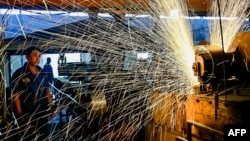 中国山东省青州市一个汽车轮辋工厂的工人正在生产线上工作。（2024年6月17日）