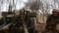 A Ukrainian soldier fires a howitzer at Russian positions near Kremenna, Luhansk region, Ukraine, April 5, 2023. U.S. officials are racing to remove leaked documents related to the war from social media platforms.