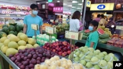 FILE - People buy fruit at a stall in Taipei, Taiwan, Sept. 20, 2021. 