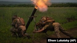 Dua tentara Ukraina menembak ke arah posisi pasukan Rusia di garis depan di Ukraina tenggara (foto: ilustrasi). Pasukan Ukraina dilaporkan kekurangan amunisi di tengah gencarnya serangan Rusia. 