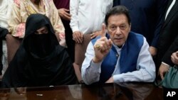 Mantan Perdana Menteri Pakistan Imran Khan, kanan, dan Bushra Bibi, istrinya, di kantor Pengadilan Tinggi Lahore di Lahore, Pakistan, pada 17 Juli. 2023. Keduanya dijatuhi hukuman 14 tahun penjara atas tuduhan korupsi. (Foto: AP)