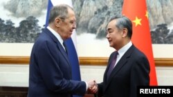 9일 세르게이 라브로프 러시아 외무장관과 왕이 중국 외교부장이 회담 전 악수를 나누고 있다.