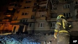 Dalam foto yang disediakan oleh Layanan Darurat Ukraina, seorang petugas pemadam kebakaran memeriksa kerusakan di sebuah gedung apartemen menyusul serangan drone Rusia di Dnipro, Ukraina, Jumat, 23 Februari 2024. (Layanan Darurat Ukraina via AP)