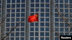 FILE - A Chinese flag flutters outside the Chinese foreign ministry in Beijing, China, Feb. 24, 2022.