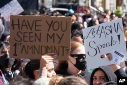Students carrying signs protest a canceled commencement speech by its 2024 valedictorian who has publicly supported Palestinians on the campus of University of Southern California, April 18, 2024.