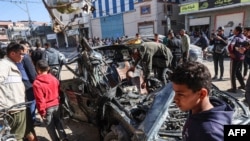 Ljudi posmatraju automobil u kojem su u Gazu ubijeni Mustafa Turija, video stringer agencije AFP i Vel Daduh, novinar Al Džazire, 7. januara 2024. (Foto: AFP)