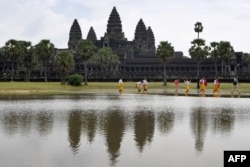 This photo taken on October 12, 2020 shows tourists walking past the Angkor Wat temple in Siem Reap province