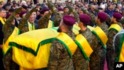 Hezbollah fighters surround the coffin of Abbas Raad, son of the head of Hezbollah's parliamentary bloc, Mohammed Raad, who was killed by an Israeli strike, during his funeral procession in Jbaa, Lebanon, Nov. 23, 2023.