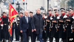 2023年11月21日，北约秘书长斯托尔滕贝格（中）在北马其顿总理科瓦切夫斯基（中左）的陪同下，在北马其顿斯科普里政府大楼检阅仪仗队。（美联社照片）