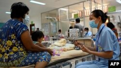 រូបឯកសារ៖ អ្នកប្រឹក្សាផ្នែកអាហារូបត្ថម្ភ​ផ្តល់​ព័ត៌មាន​ដល់​ជីដូន​របស់​កុមារ​ម្នាក់ នៅ​មន្ទីរ​កុមារ​អង្គរ ក្នុងខេត្ត​សៀមរាប កាលពីថ្ងៃទី៦ ខែកក្កដា ឆ្នាំ២០២២។ 