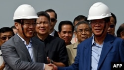 នាយករដ្ឋមន្ត្រីកម្ពុជា លោក ហ៊ុន សែន ចាប់ដៃជាមួយឯកអគ្គរដ្ឋទូតចិនប្រចាំកម្ពុជា លោក Wang Wentian នៅក្នុងពិធីសម្ពោធបើកដំណើរការនៃការដ្ឋានសាងសង់ផ្លូវល្បឿនលឿន​ចម្ងាយ ១៣៥គីឡូម៉ែត្រ ពីរាជធានីភ្នំពេញ ទៅក្រុងបាវិតនៃខេត្តស្វាយរៀង កាលពីថ្ងៃទី ៧ ខែមិថុនា ឆ្នាំ ២០២៣។ 