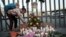 Seorang anak perempua menyalakan lilin untuk mengenang para korban kebakaran di pusat penahanan imigrasi yang menewaskan puluhan orang di Ciudad Juarez, Meksiko, Selasa, 28 Maret 2023. (AP/Christian Chavez)