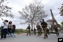 FILE - Soldiers patrol along a construction site for the upcoming Olympic Games, at the Trocadero gardens, April 11, 2024 in Paris, France.