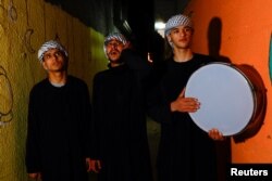 Kelompok Mesaharati Palestina membangunkan umat Islam untuk sahur sepanjang hari, selama bulan suci Ramadan, di Khan Younis, Jalur Gaza selatan, 25 Maret 2023. (REUTERS/Ibraheem Abu Mustafa)