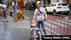 People wear hats and carry handmade fans to cool down from the extreme heat in Bangkok, Thailand, April 23, 2023.