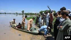 Warga yang mengungsi tiba dengan perahu melintasi daerah banjir setelah hujan lebat di distrik Nowshera, provinsi Khyber-Pakhtunkhwa, Pakistan Selasa, 16 April 2024.