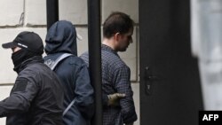 FILE - U.S. journalist Evan Gershkovich, right, is escorted outside the Lefortovsky Court in Moscow on Aug. 24, 2023.