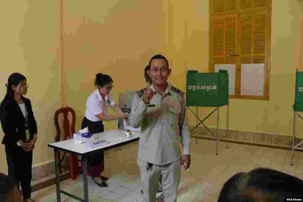 អង្គ​បោះឆ្នោត​មួយ​រូប​លើក​ដៃ​ជ្រលក់​ទឹក​ថ្នាំ ​ក្រោយ​ការ​បោះឆ្នោត​ជ្រើស​រើស​សមាជិក​ព្រឹទ្ធសភា នៅ​មណ្ឌល​បោះឆ្នោត​វិទ្យាល័យ​ព្រះស៊ីសុវត្ថិ ក្នុង​រាជធានី​ភ្នំពេញ នា​ថ្ងៃទី​២៥ ខែ​កុម្ភៈ ឆ្នាំ​២០២៤។ (ស៊ុន ណារិន/វីអូអេ)