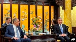 Russian Foreign Minister Sergey Lavrov, left, and Chinese Foreign Minister Wang Yi are seen during their meeting in Beijing, China, April 8, 2024. (Russian Foreign Ministry Press Service via AP)