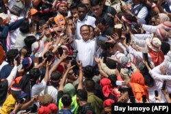 Calon presiden dan wakil presiden, Anies Baswedan (tengah) dan Muhaimin Iskandar (belakang tengah), menyapa pendukungnya saat kampanye di Jakarta International Stadium, Jakarta pada 10 Februari 2024. (Foto: AFP/Bay ismoyo)