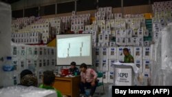 Pejabat Komisi Pemilihan Umum (KPU) dan saksi partai melakukan rekapitulasi hasil tabulasi di tingkat kecamatan di Jakarta pada 16 Februari 2024. (Foto: AFP/Bay Ismoyo)