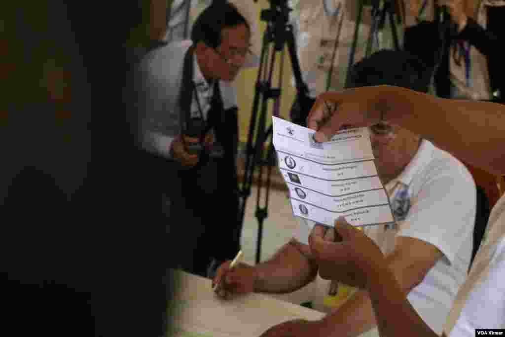 មន្រ្តី​រៀប​ចំ​ការ​បោះ​ឆ្នោត​ម្នាក់​បង្ហាញ​សន្លឹក​ឆ្នោត​ដែល​មាន​គូស​ចំ​គណបក្ស​ប្រជាជន​កម្ពុជា នៅ​មណ្ឌល​​ក្នុង​វិទ្យាល័យ​ព្រះស៊ីសុវត្ថិ ក្នុង​រាជធានី​ភ្នំពេញ នា​ថ្ងៃទី​២៥ ខែ​កុម្ភៈ ឆ្នាំ​២០២៤។ (ស៊ុន ណារិន/វីអូអេ)