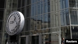 FILE - A man walks past the headquarters of the Central Bank of Iraq in Baghdad, Aug. 15, 2023.