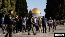 Sejumlah pasukan keamanan Israel terlihat berjalan di samping para pengunjung di Masjid Al-Aqsa, di Yerusalem, pada 5 April 2023. (Foto: Reuters/Ammar Awad)