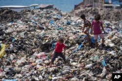 Anak-anak Palestina memilah sampah di tempat pembuangan sampah di kamp pengungsi Nuseirat, Jalur Gaza, 20 Juni 2024. (Foto: AP)