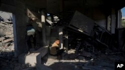 Palestinians inspect a house after it was hit by an Israeli airstrike in Deir al Balah, Gaza, Dec. 4, 2023.