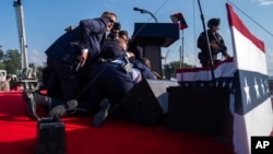 Republican presidential candidate former President Donald Trump is surrounded by U.S. Secret Service agents at a campaign rally, July 13, 2024, in Butler, Pennsylvania. 